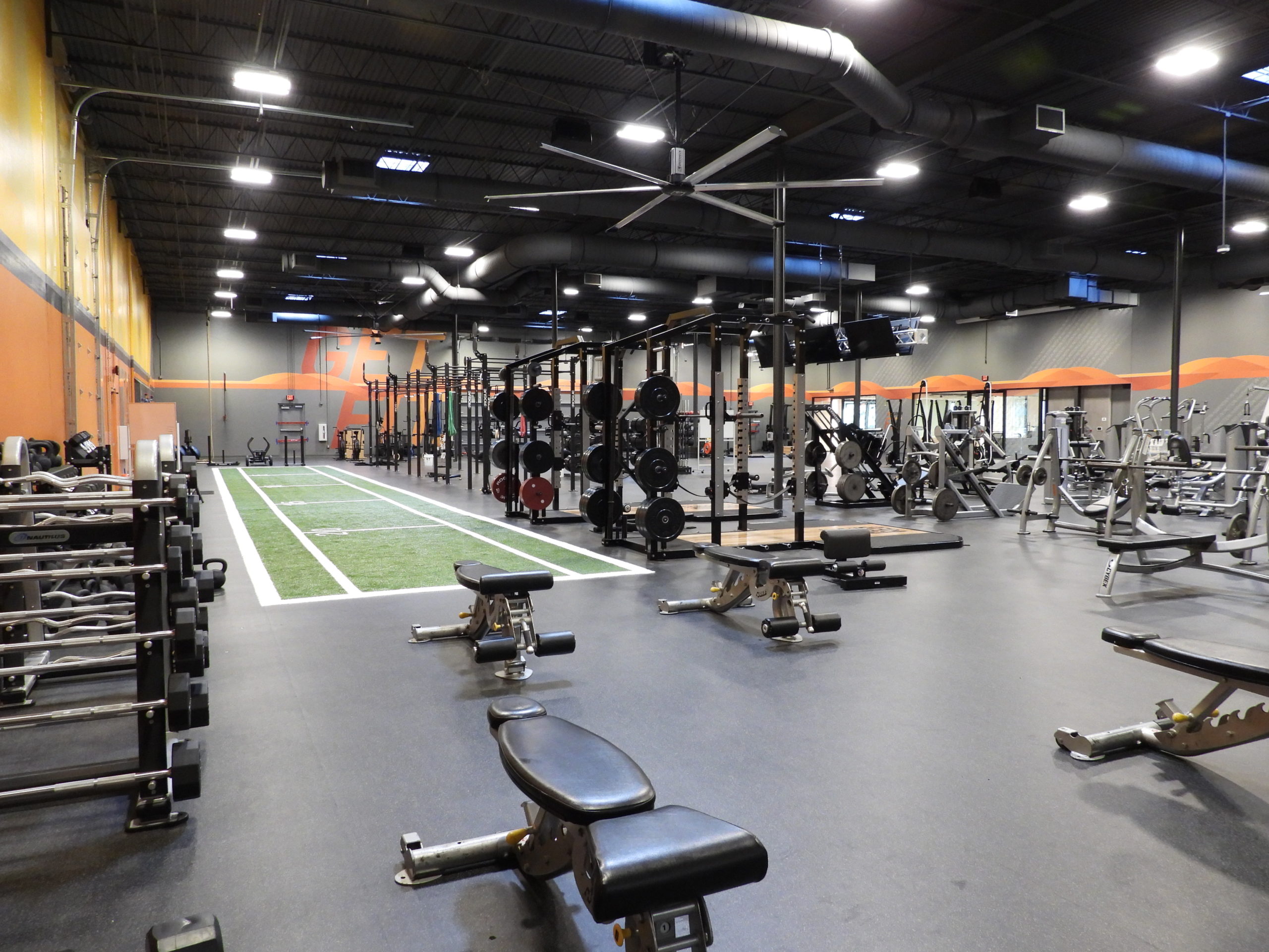 Interior photo of ParkerFit facility featuring workout equipment and a small synthetic grass field.